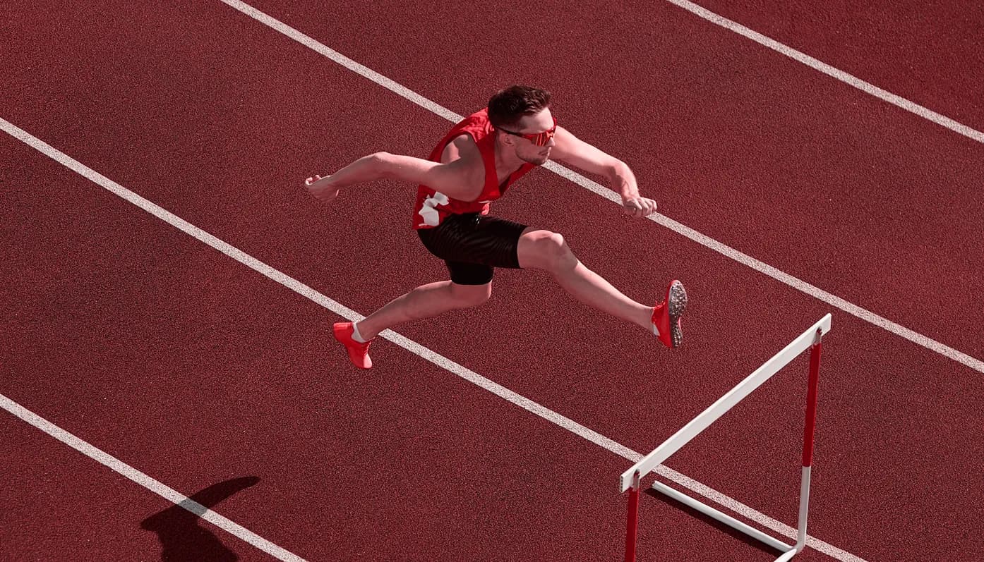 Hurdler clearing a hurdle on a track