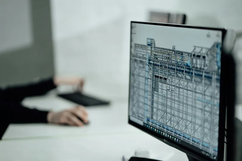 Computer monitor displaying a structural wireframe model of a building