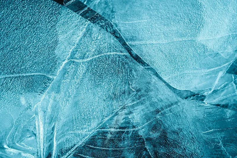 Thin, broken ice atop frozen body of water