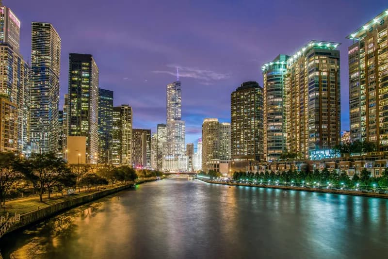 Chicago skyline at dusk with illuminated skyscrapers along the river