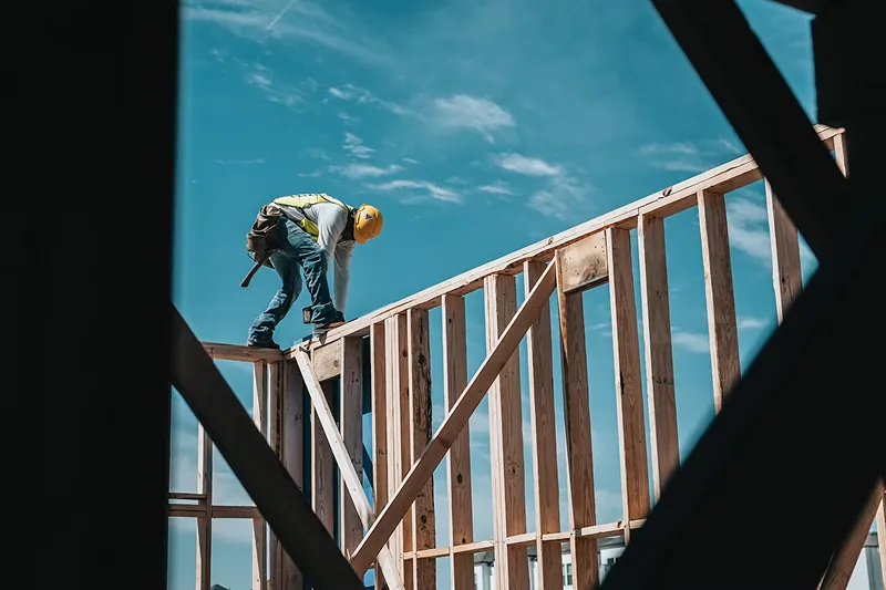 Construction worker framing a wooden wall on a building site