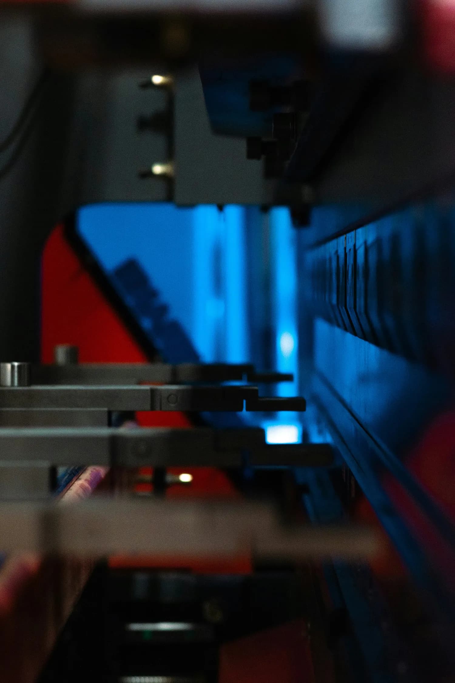 a close up of a machine with blue lights during a manufacturing process