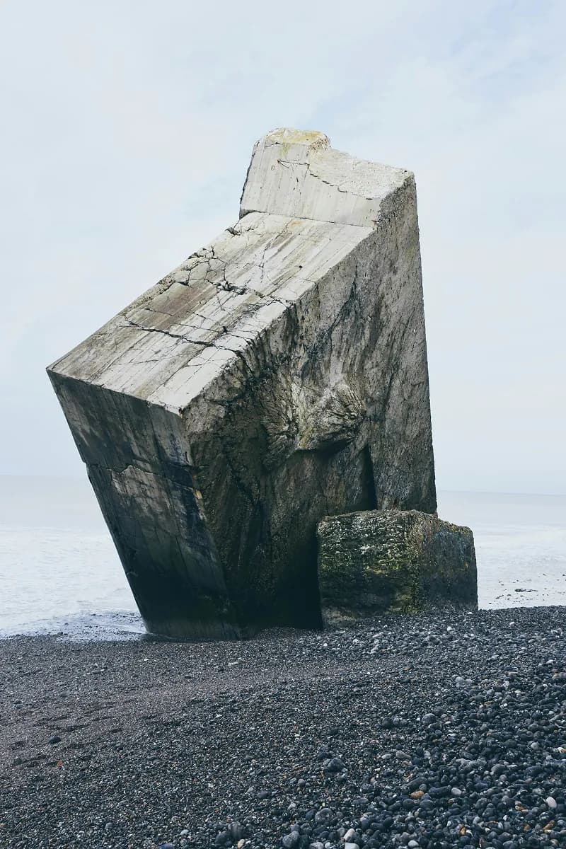 Large concrete block on a rocky beach by the sea