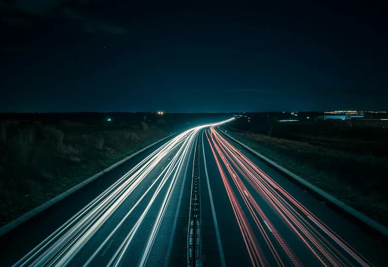 Night highway with long-exposure light trails from passing traffic