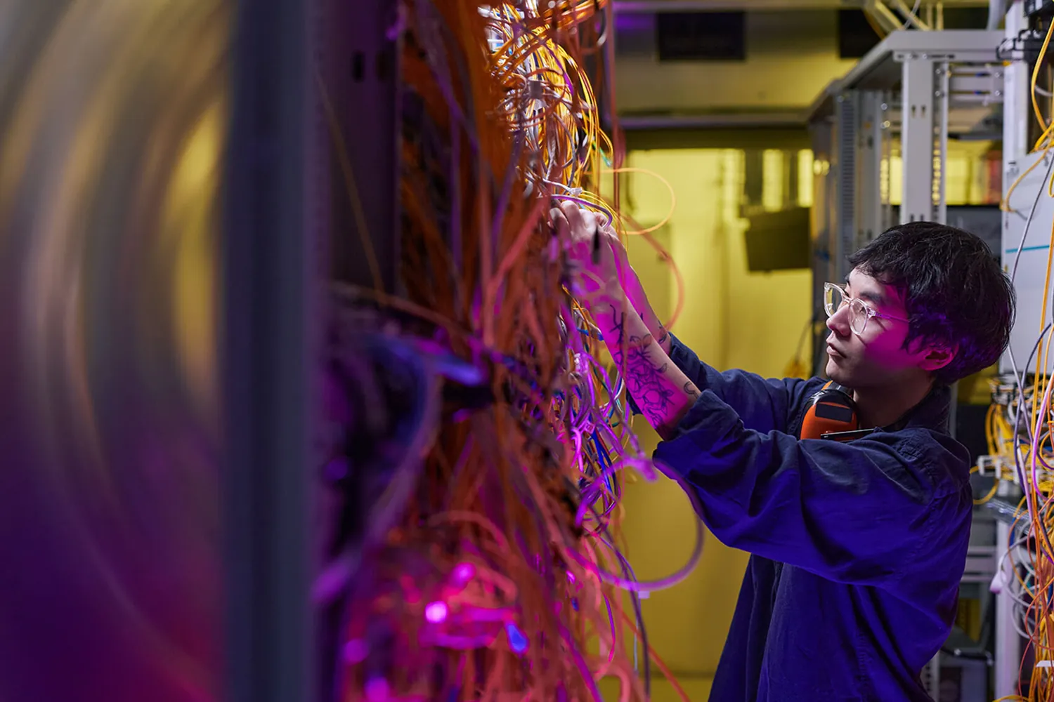 Technician connecting cables in a server room