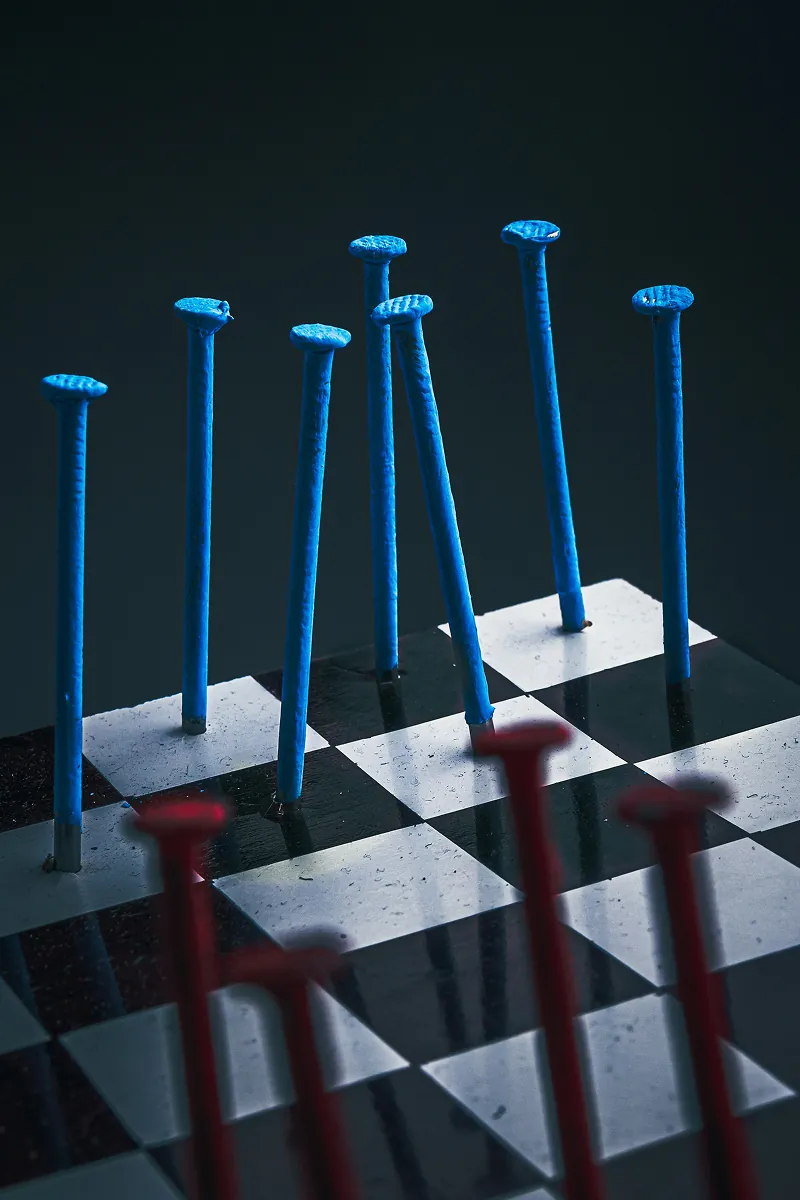 Blue and red pins arranged on a black-and-white checkerboard surface