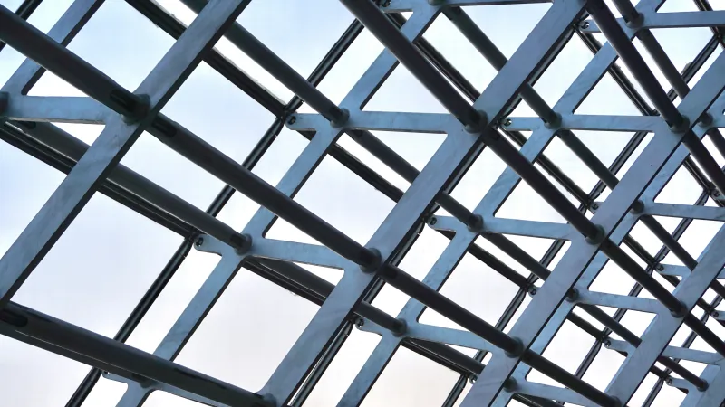 Black metal beams forming a grid-like geometric pattern