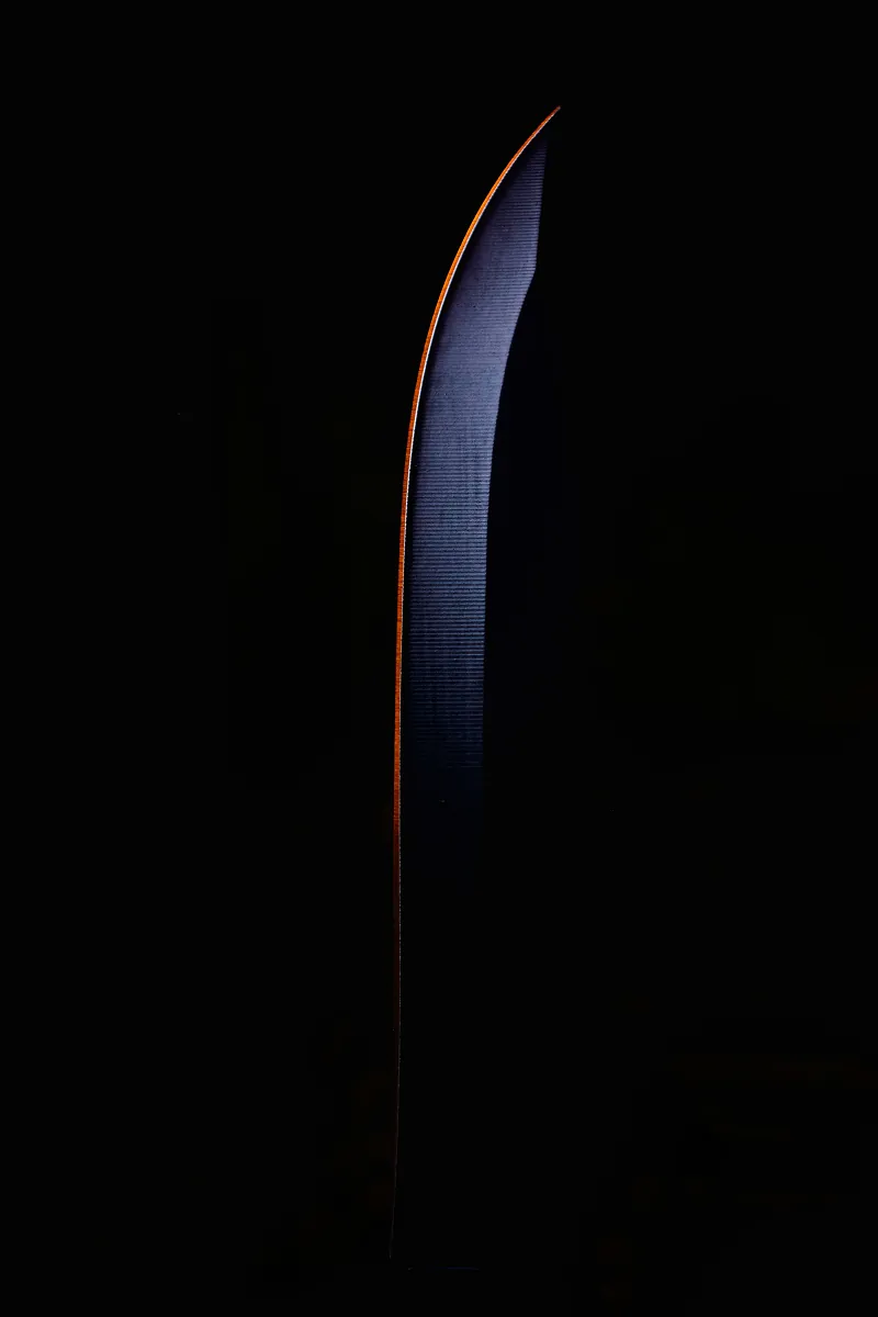 A single curved blue blade-shaped object with an orange edge on a black background